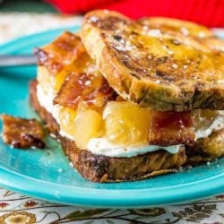 Apple bacon maple french toast sandwich on a teal plate