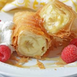 Banana fried cheesecake cut in half with raspberries