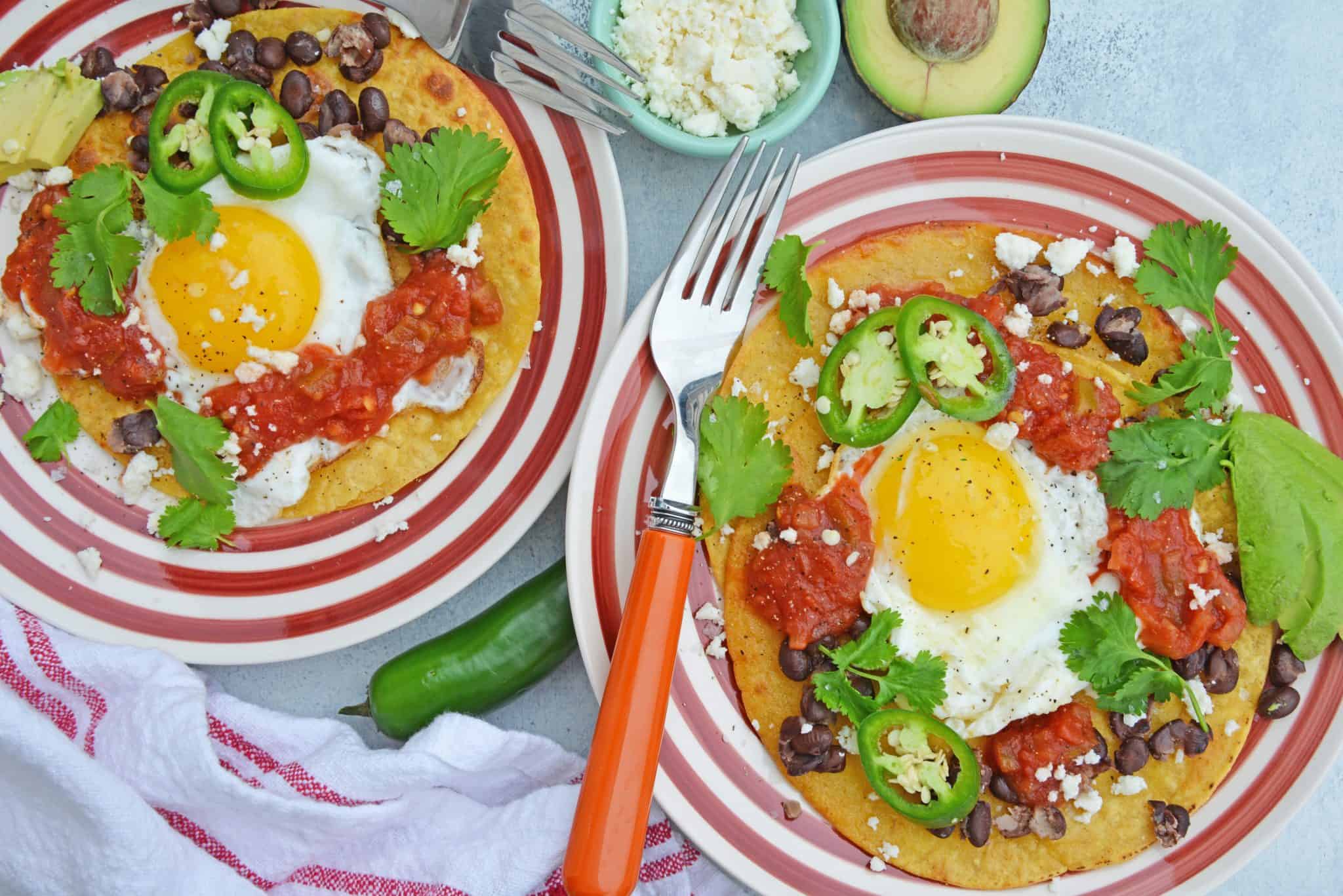 Huevos Rancheros are a great way to spice up your breakfast. Lacey eggs with a runny yolk over warm corn tortillas, chunky salsa, black beans, cilantro and queso fresco. #huevosrancheros www.savoryexperiments.com 