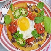 Huevos Rancheros are a great way to spice up your breakfast. Lacey eggs with a runny yolk over warm corn tortillas, chunky salsa, black beans, cilantro and queso fresco. #huevosrancheros www.savoryexperiments.com