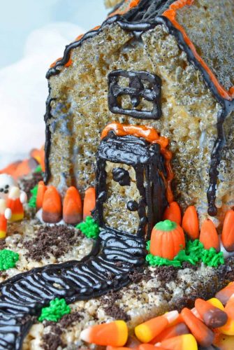 With this Rice Krispie Treat house template, you can make an adorable haunted house to display and then eat. Similar to a gingerbread house, this is part Halloween craft and party Halloween dessert. Fun and easy! #hauntedhouse #halloweendesserts www.savoryexperiments.com