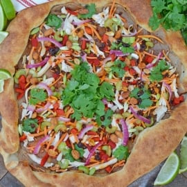 Spicy Thai Chicken Pizza uses a rich peanut satay sauce with shredded chicken, colorful vegetables and topped with sweet honey roasted peanuts and spicy chili oil. #thaichicken #homemadepizza www.savoryexperiments.com
