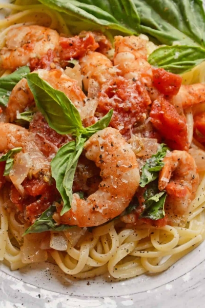 Tomato Basil Shrimp Pasta is an easy and healthy shrimp pasta recipe. It's great for busy weeknights but full of flavor and sure to impress guests! #shrimppasta #shrimpmeals #shrimppastarecipe www.savoryexperiments.com