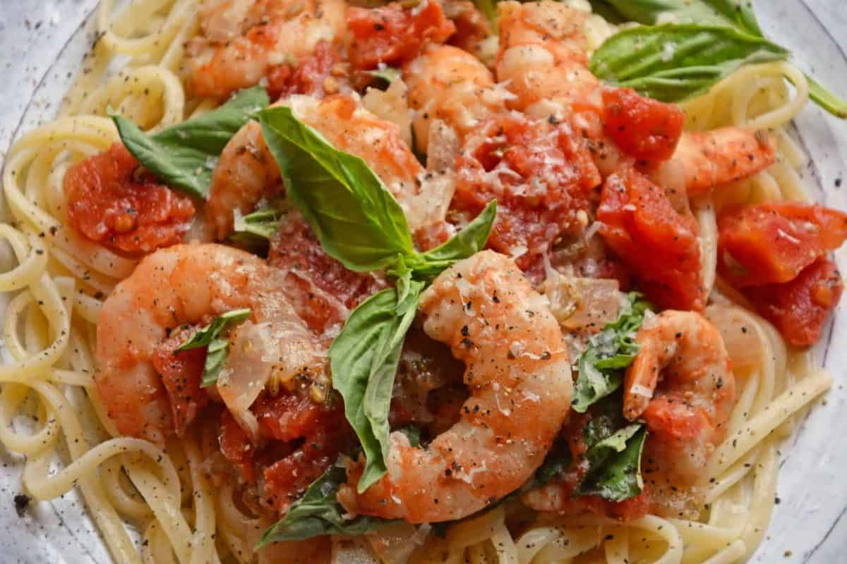 Tomato Basil Shrimp Pasta is an easy and healthy shrimp pasta recipe. It's great for busy weeknights but full of flavor and sure to impress guests! #shrimppasta #shrimpmeals #shrimppastarecipe www.savoryexperiments.com