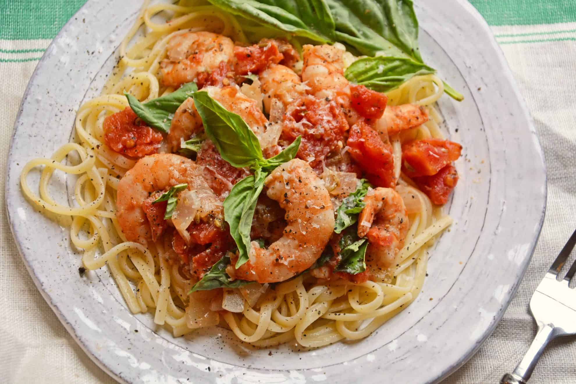 Tomato Basil Shrimp Pasta is an easy and healthy shrimp pasta recipe. It's great for busy weeknights but full of flavor and sure to impress guests! #shrimppasta #shrimpmeals #shrimppastarecipe www.savoryexperiments.com