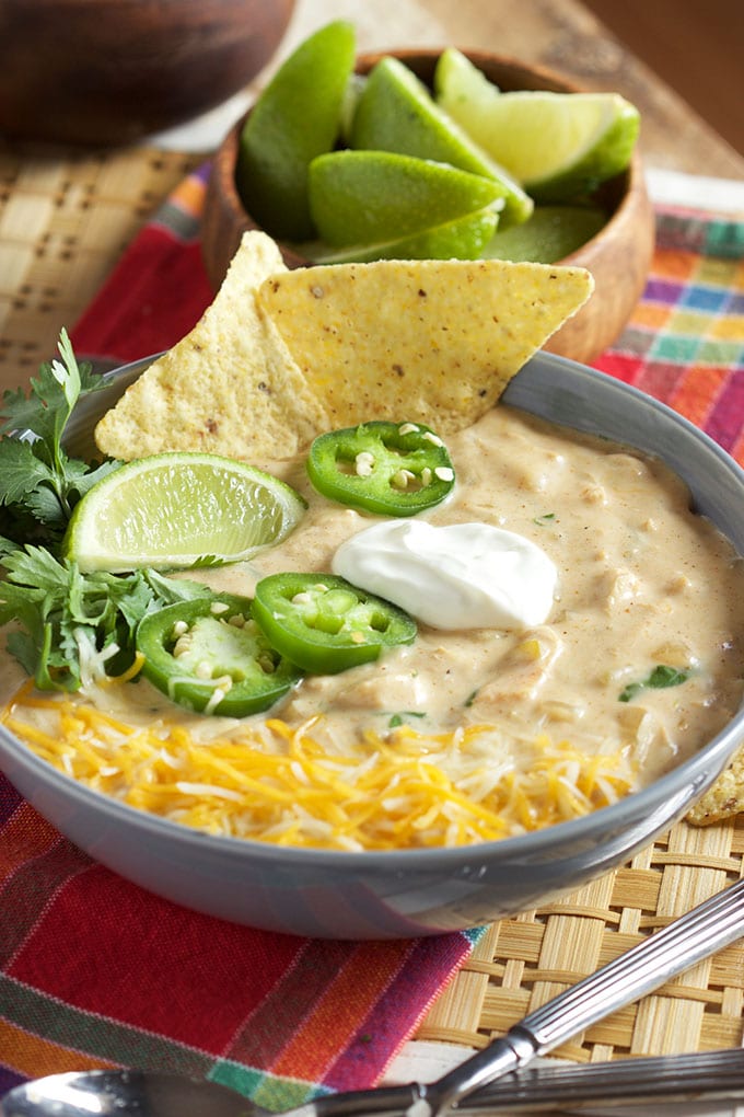 White chicken chili in a blue bowl with tortilla chips