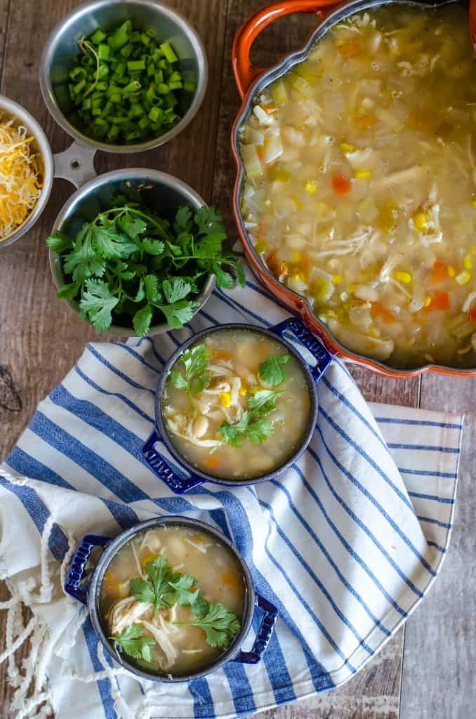 White chicken chili in two bowls on a white and blue napkin