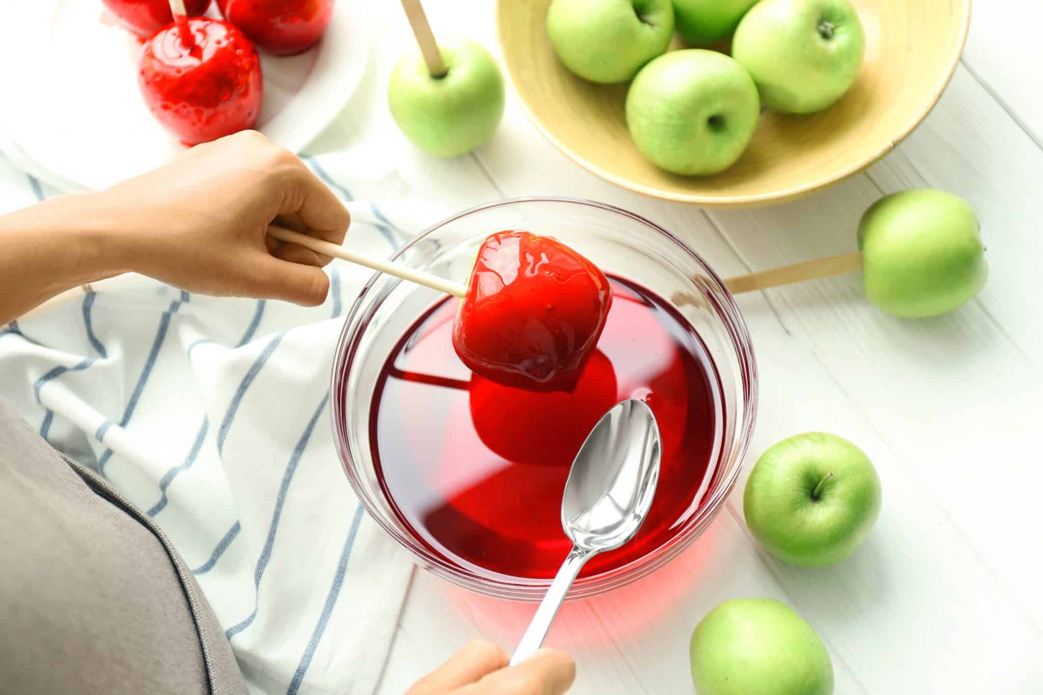 The classic candied apple is a beautifully colorful, glassy red apple. A lollipop candy coating with lush and slightly sour crunchy apple inside. #candiedapples www.savoryexperiments.com 