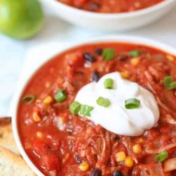 Jackfruit chili in a whote bowl topped with sour cream