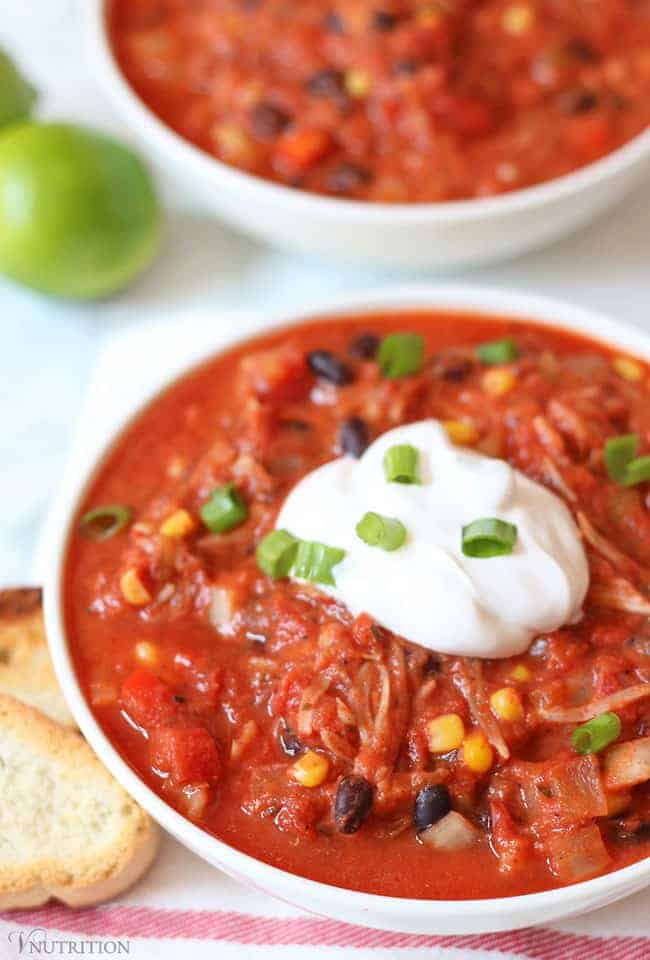 Jackfruit chili in a whote bowl topped with sour cream