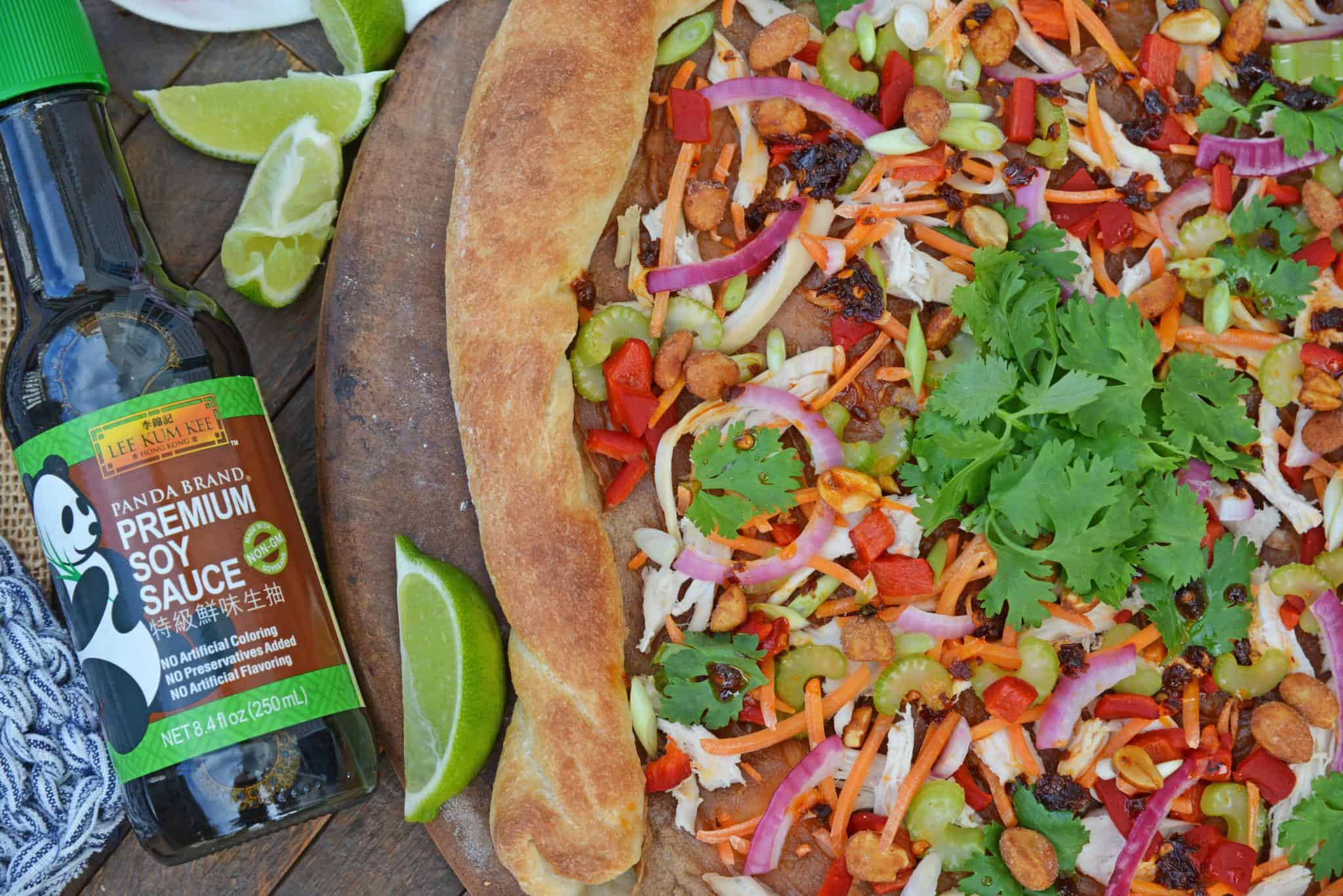 Spicy Thai Chicken Pizza uses a rich peanut satay sauce with shredded chicken, colorful vegetables and topped with sweet honey roasted peanuts and spicy chili oil. #thaichicken #homemadepizza www.savoryexperiments.com 