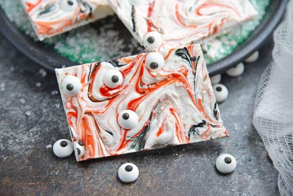 Monster Bark is a quick and easy Halloween treat made with candy eyeballs. Always a hit with kids, it's the perfect Halloween dessert for any party! #monsterbark #howtomakechocolatebark #candyeyeballs www.savoryexperiments.com