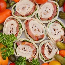 Turkey club pinwheel recipes with veggies on a tray