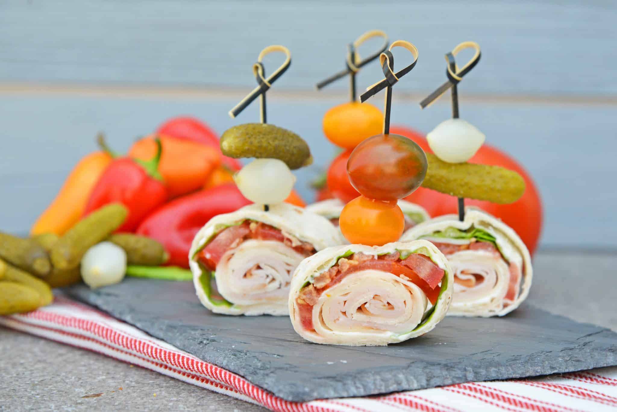 Turkey Club Sandwich Pinwheels use the traditional club sandwich ingredients, but wrap them in a tortilla. Easy to make, eat and clean up! #clubsandwichrecipe #turkeyclub #howtomakepinwheels www.savoryexperiments.com