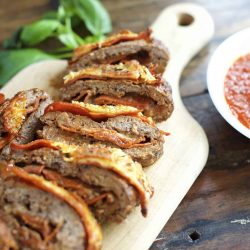 Pizza meatloaf cut into slices on a cutting board