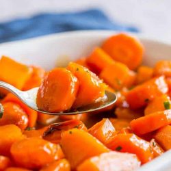 Thanksgiving sides close up of bourbon glazed carrots in a white dish