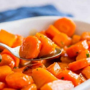 Thanksgiving sides close up of bourbon glazed carrots in a white dish