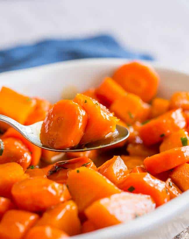 Thanksgiving sides close up of bourbon glazed carrots in a white dish