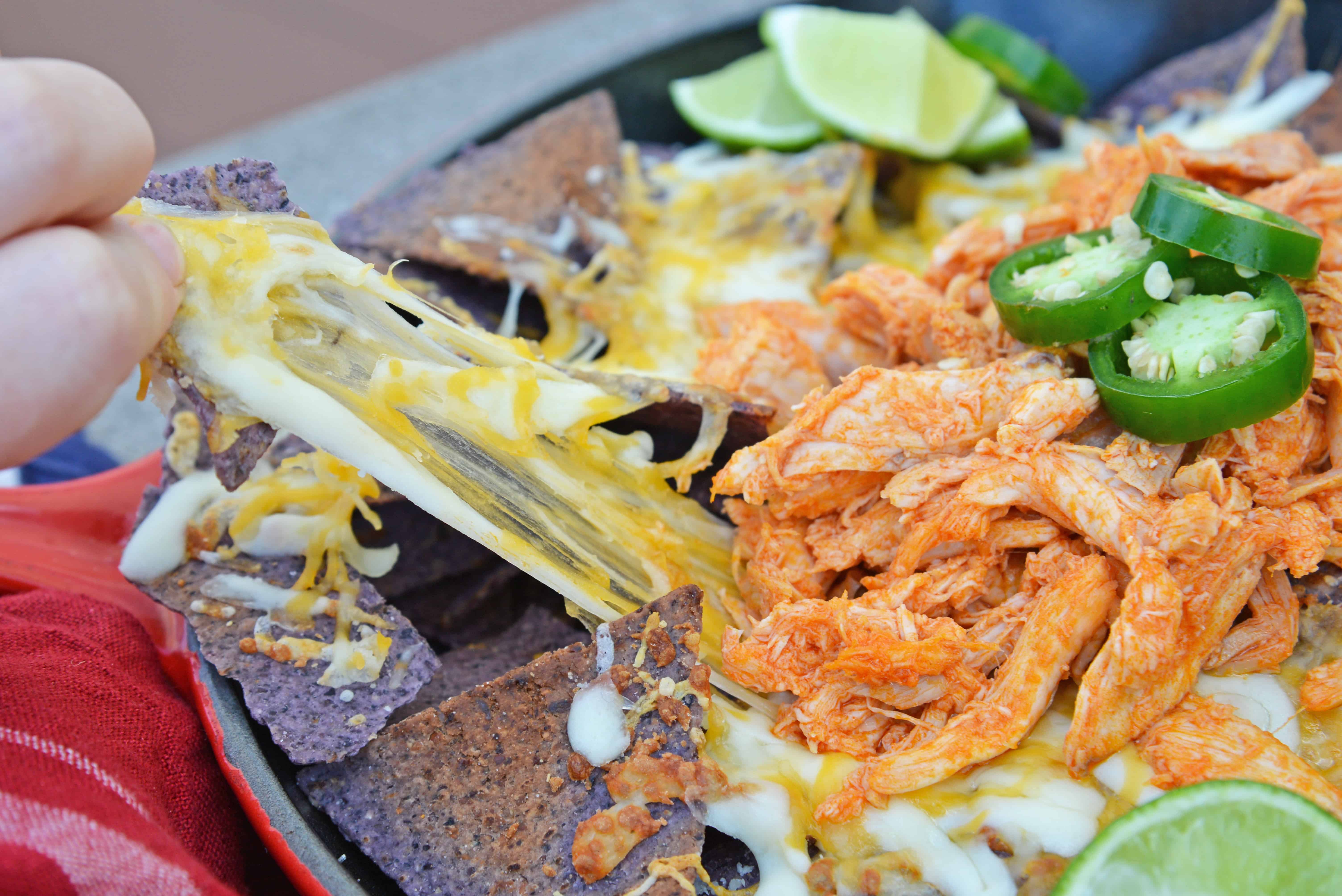 Buffalo Chicken Nachos is an easy nachos recipe that is perfect for a quick Tex Mex meal or game day appetizer. Ready in minutes with few ingredients! #buffalochickennachos #buffalochicken #nachosrecipe www.savoryexperiments.com