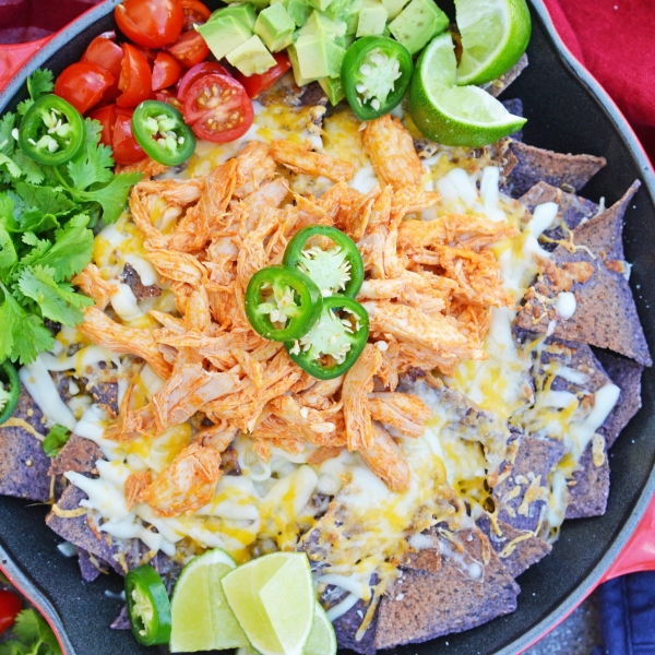 Buffalo Chicken Nachos is an easy nachos recipe that is perfect for a quick Tex Mex meal or game day appetizer. Ready in minutes with few ingredients! #buffalochickennachos #buffalochicken #nachosrecipe www.savoryexperiments.com