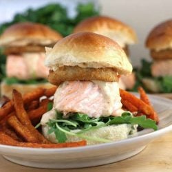 Cajun salmon slider sandwich recipes on a white plate with sweet potato fries