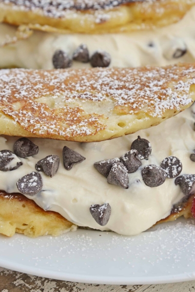 Cannoli Pancakes are stuffed with a rich, delicious cannoli filling. This breakfast cannoli is perfect for special breakfasts and brunches. #cannolipancakes #breakfastcannoli #cannolifilling www.savoryexperiments.com