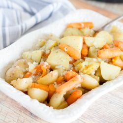 angled shot of potatoes and carrot in baking dish