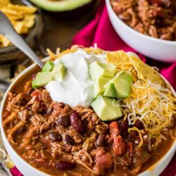 Turkey chili in a white bowl with sour cream and cheese - leftover turkey recipes