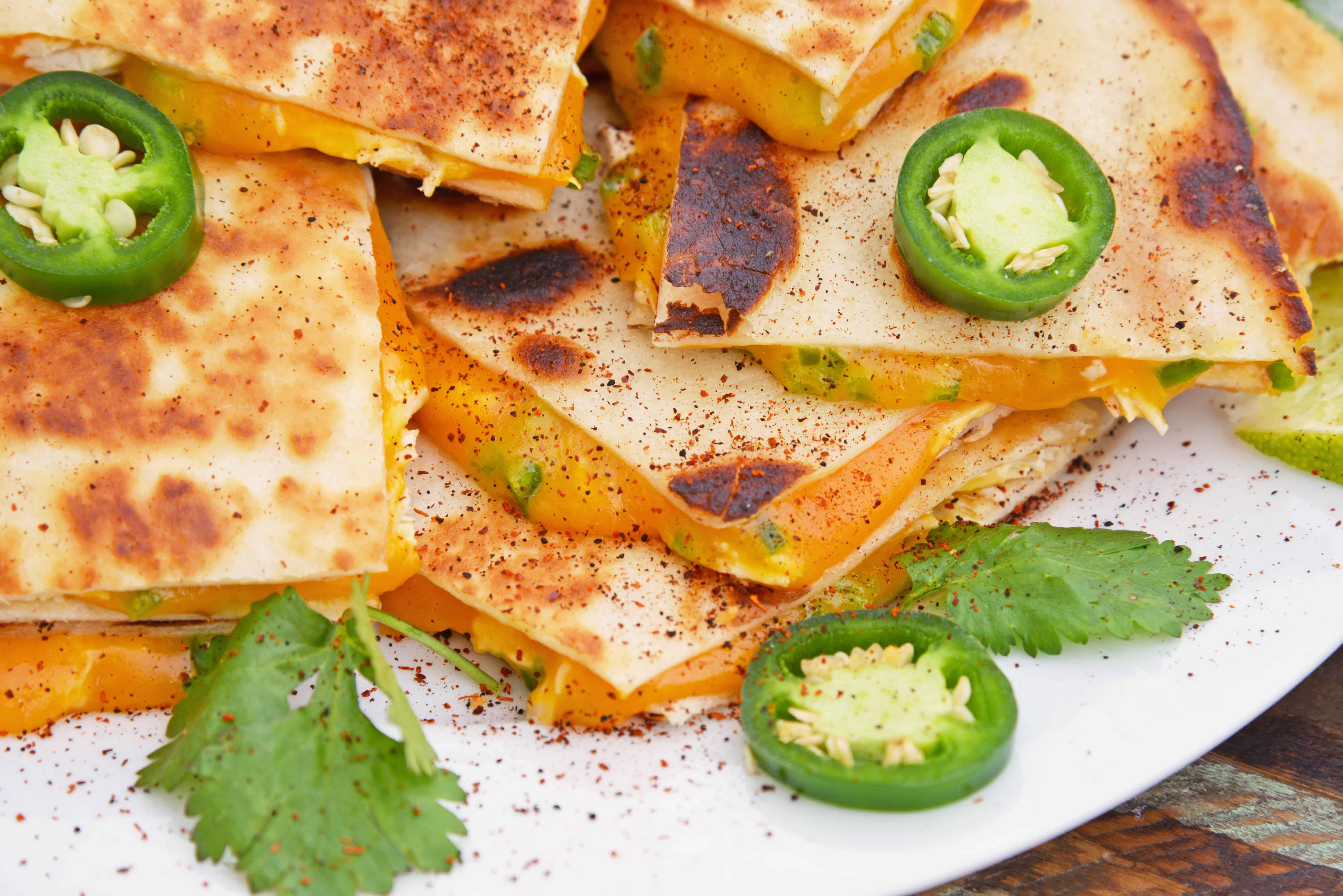 Cheesy, spicy and shareable Cheesy Jalapeño Quesadillas are the gooey appetizer everyone loves. Stacked with cheddar cheese, fresh jalapeños and shredded chicken, they are ready in just 10 minutes! #cheesequesadillas www.savoryexperiments.com