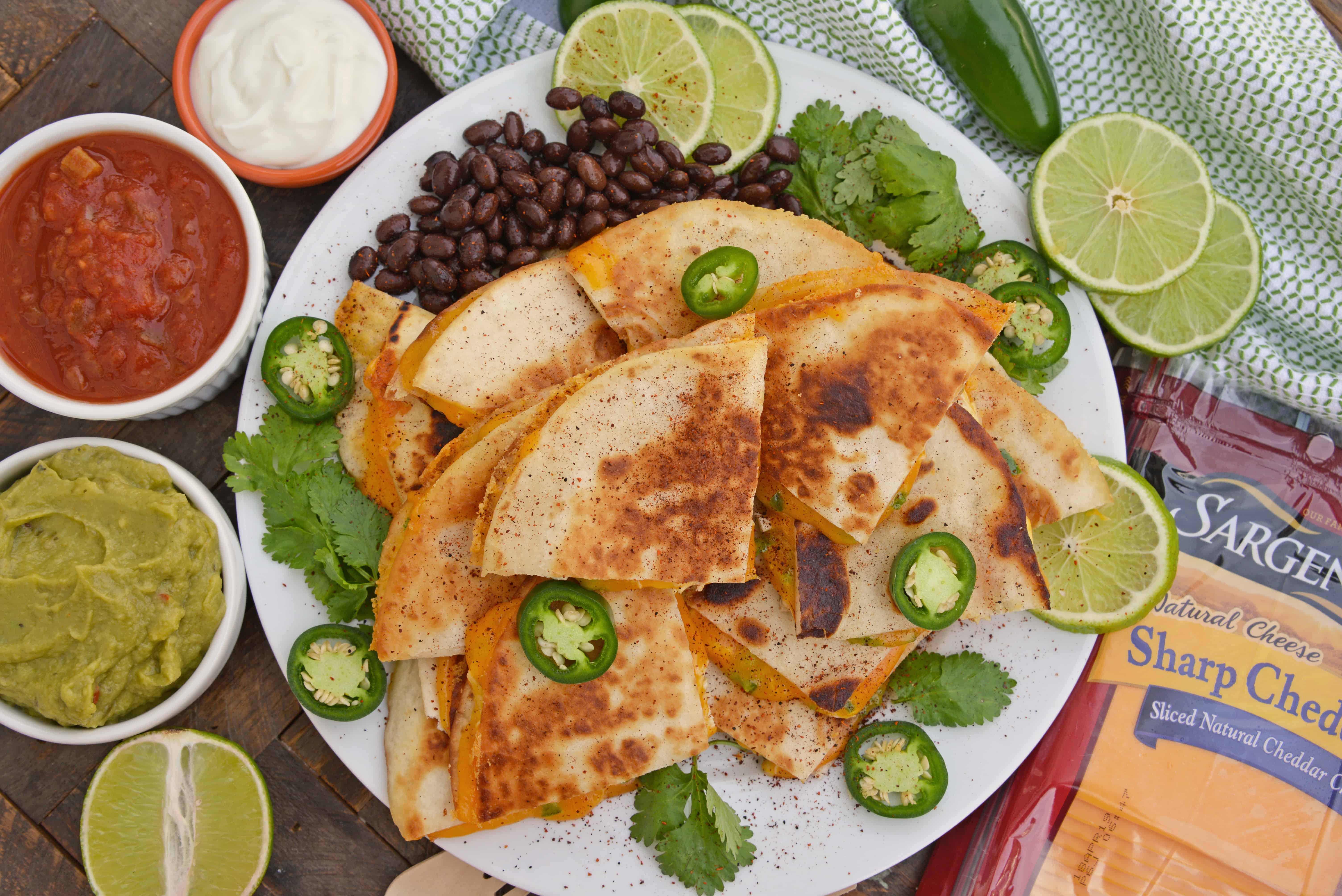 Cheesy, spicy and shareable Cheesy Jalapeño Quesadillas are the gooey appetizer everyone loves. Stacked with cheddar cheese, fresh jalapeños and shredded chicken, they are ready in just 10 minutes! #cheesequesadillas www.savoryexperiments.com