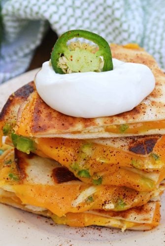 Cheesy, spicy and shareable Cheesy Jalapeño Quesadillas are the gooey appetizer everyone loves. Stacked with cheddar cheese, fresh jalapeños and shredded chicken, they are ready in just 10 minutes! #cheesequesadillas www.savoryexperiments.com