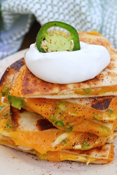 Cheesy, spicy and shareable Cheesy Jalapeño Quesadillas are the gooey appetizer everyone loves. Stacked with cheddar cheese, fresh jalapeños and shredded chicken, they are ready in just 10 minutes! #cheesequesadillas www.savoryexperiments.com