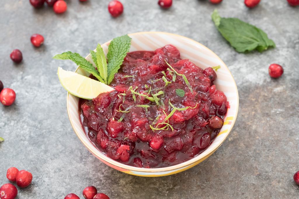 Thanksgiving sides mojito cranberry sauce in a white bowl with mint and lime