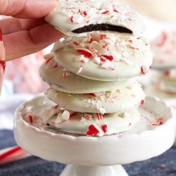 Peppermint bark cookies stacked on a white tray