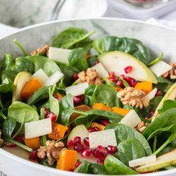 Thanksgiving sides roast pumpkin pear salad in a white bowl