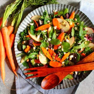 Thanksgiving sides carrot apple pistachio salad with wooden utensils