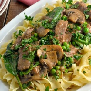 Skinny Beef Stroganoff use a secret ingredient to make this into a low calorie creamy dish. Add peas and spinach for extra veggie! #beefstroganoff www.savoryexperiments.com