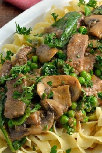 Skinny Beef Stroganoff use a secret ingredient to make this into a low calorie creamy dish. Add peas and spinach for extra veggie! #beefstroganoff www.savoryexperiments.com