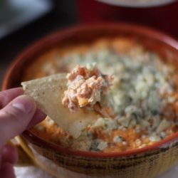 Buffalo turkey dip in a crock with a chip - leftover turkey recipes