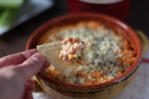 Buffalo turkey dip in a crock with a chip - leftover turkey recipes