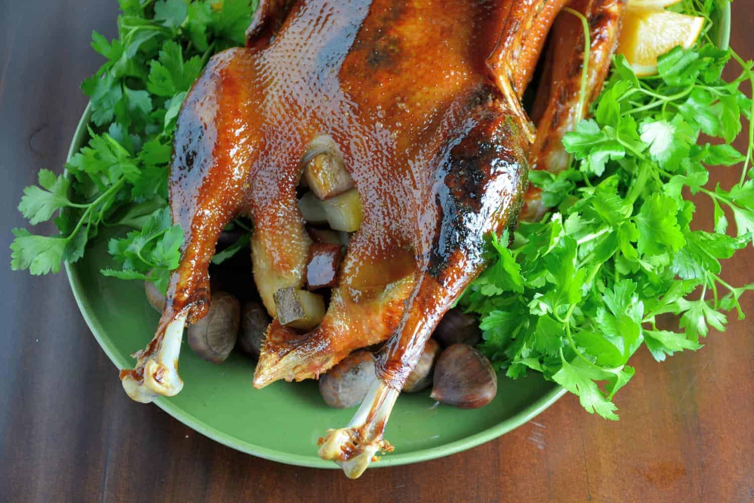 Sweet Roasted Goose is a tried and true recipe for a succulent goose with crispy skin and tender meat seasoned with apple, orange and potato stuffing. Top with Cumberland Sauce. #howtocookgoose #roastgoose www.savoryexperiments.com