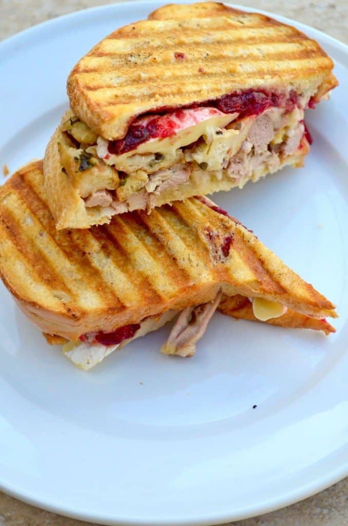 Thanksgiving panini cut in half on a white plate - leftover turkey recipes