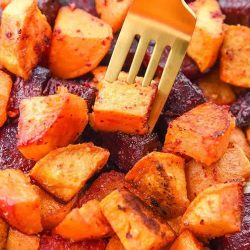 Thanksgiving sides close up of roasted beets and sweet potatoes on a fork