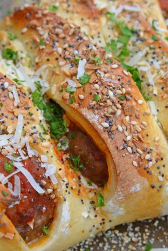 Everything Meatball Stromboli is meatballs, marinara sauce and cheese wrapped in pizza dough topped with everything bagel seasoning. An easy weeknight meal recipe! #howtomakestromboli #strombolirecipe #meatballstromboli www.savoryexperiments.com