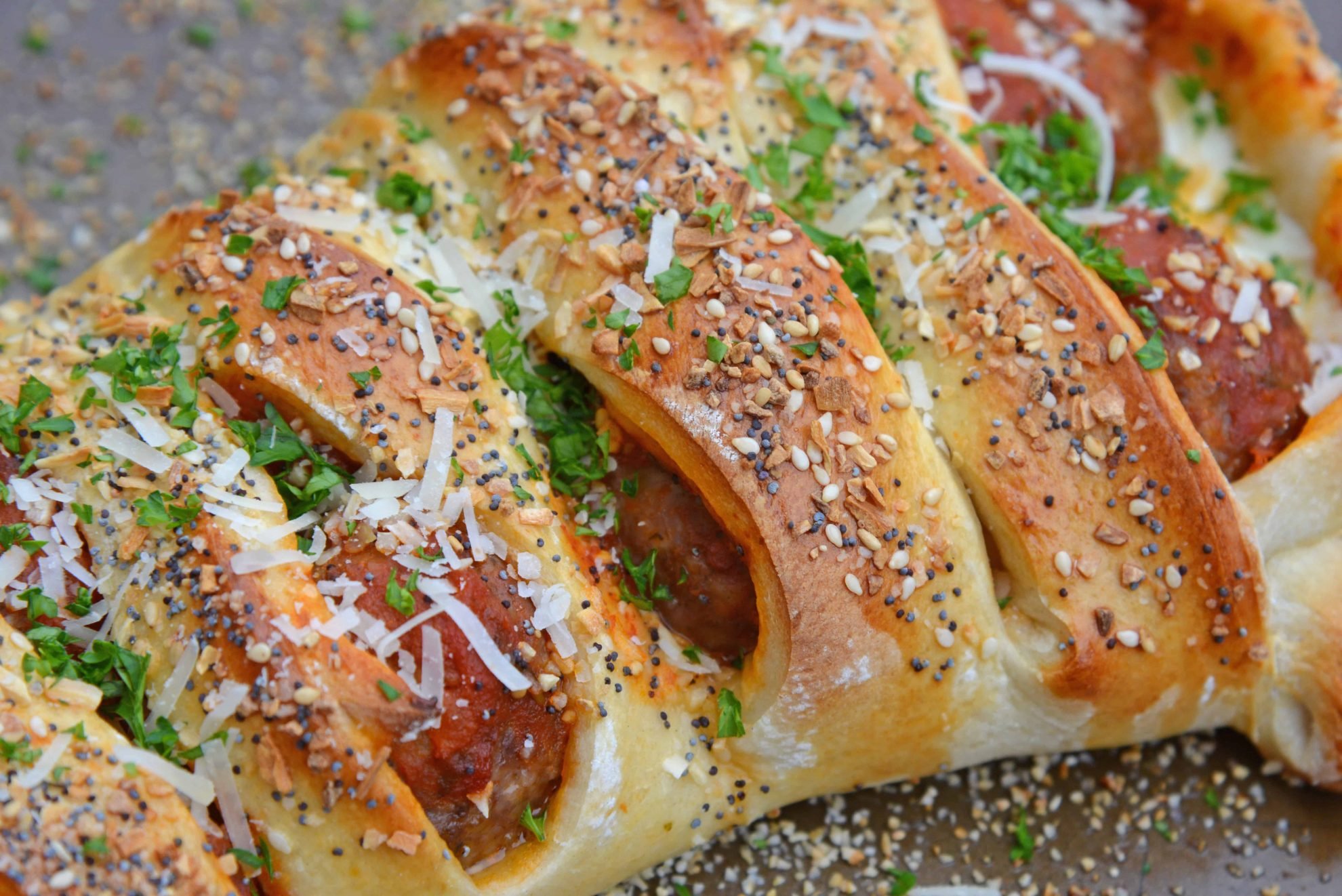 Everything Meatball Stromboli is meatballs, marinara sauce and cheese wrapped in pizza dough topped with everything bagel seasoning. An easy weeknight meal recipe! #howtomakestromboli #strombolirecipe #meatballstromboli www.savoryexperiments.com 