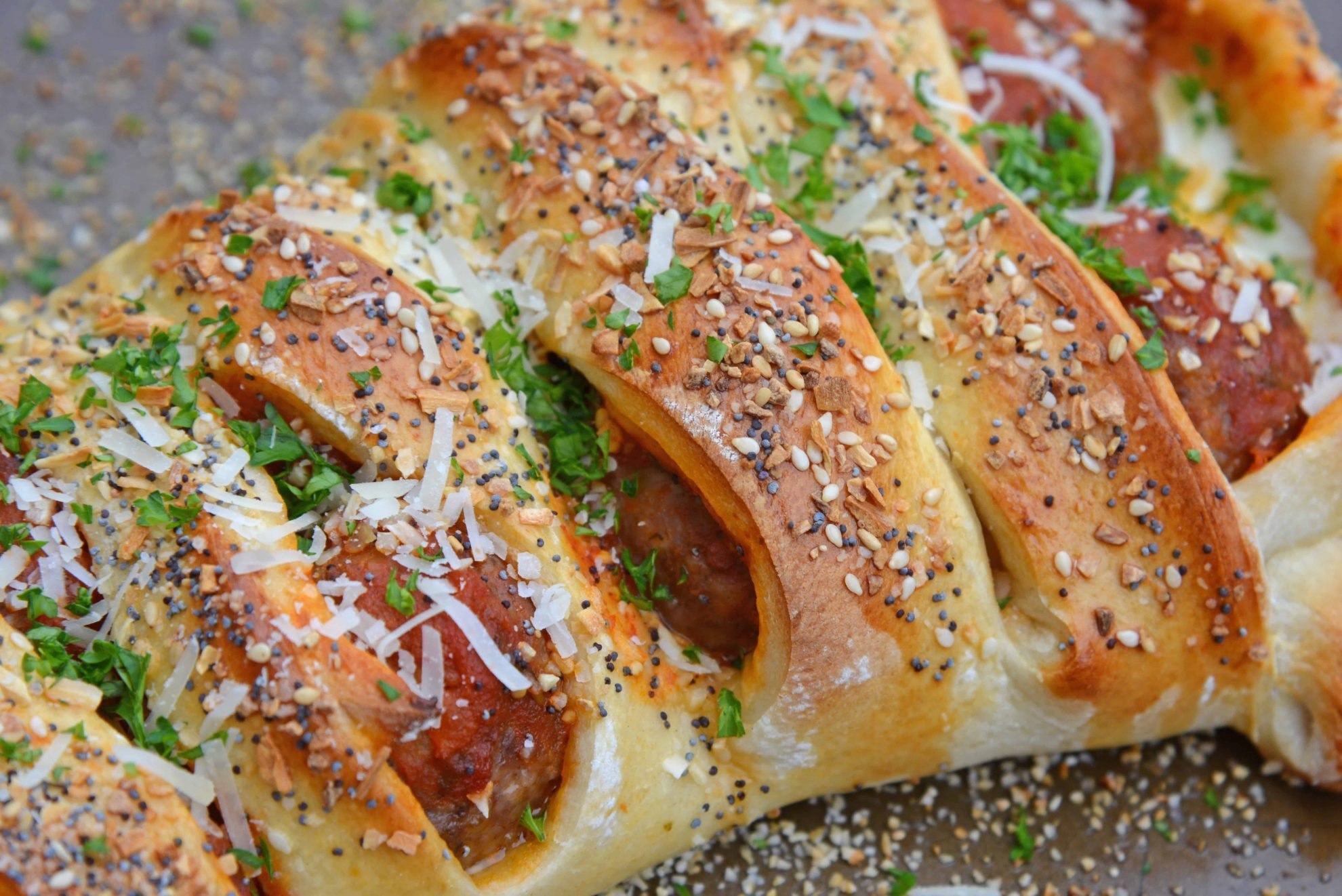 Everything Meatball Stromboli is meatballs, marinara sauce and cheese wrapped in pizza dough topped with everything bagel seasoning. An easy weeknight meal recipe! #howtomakestromboli #strombolirecipe #meatballstromboli www.savoryexperiments.com