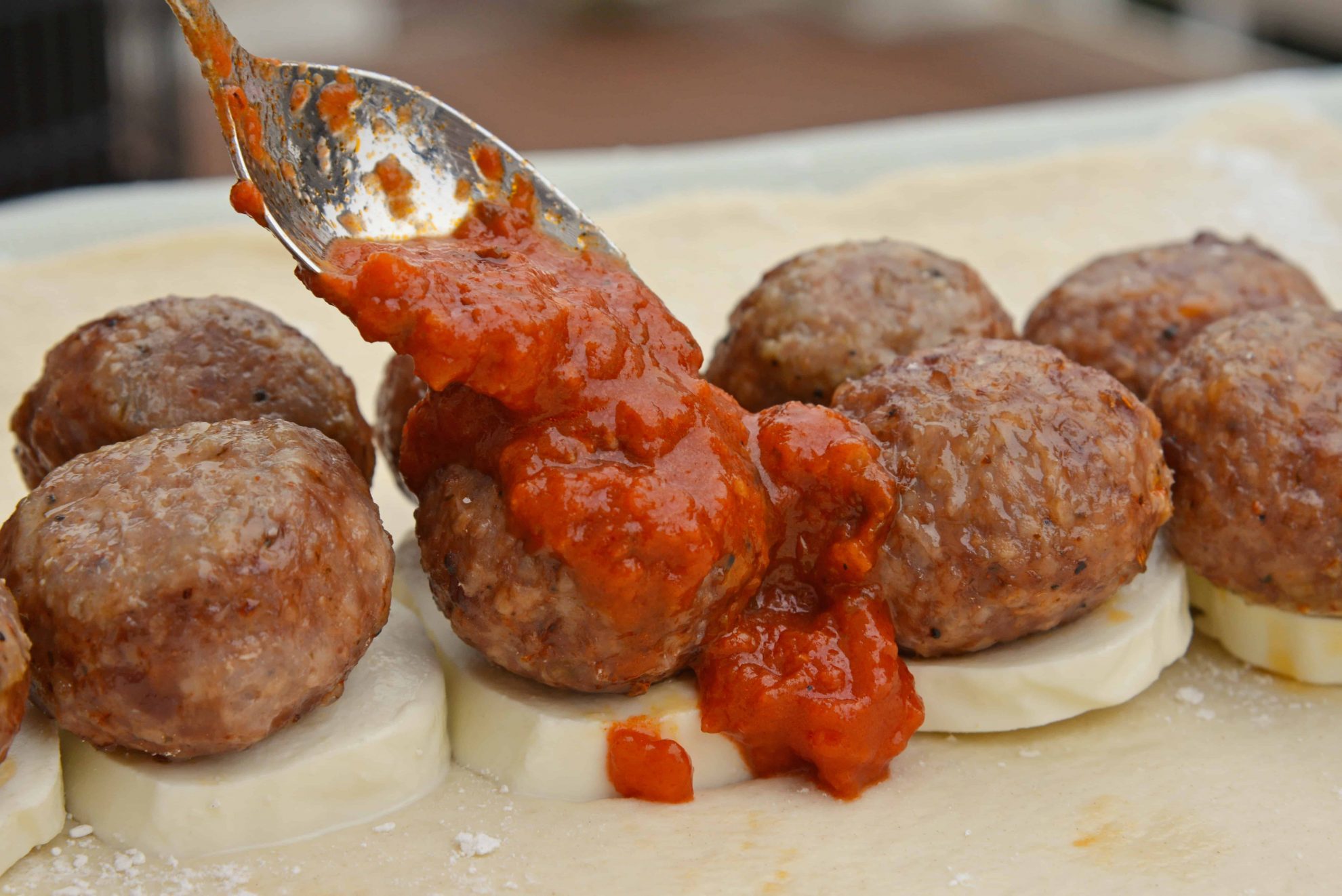 Everything Meatball Stromboli is meatballs, marinara sauce and cheese wrapped in pizza dough topped with everything bagel seasoning. An easy weeknight meal recipe! #howtomakestromboli #strombolirecipe #meatballstromboli www.savoryexperiments.com 