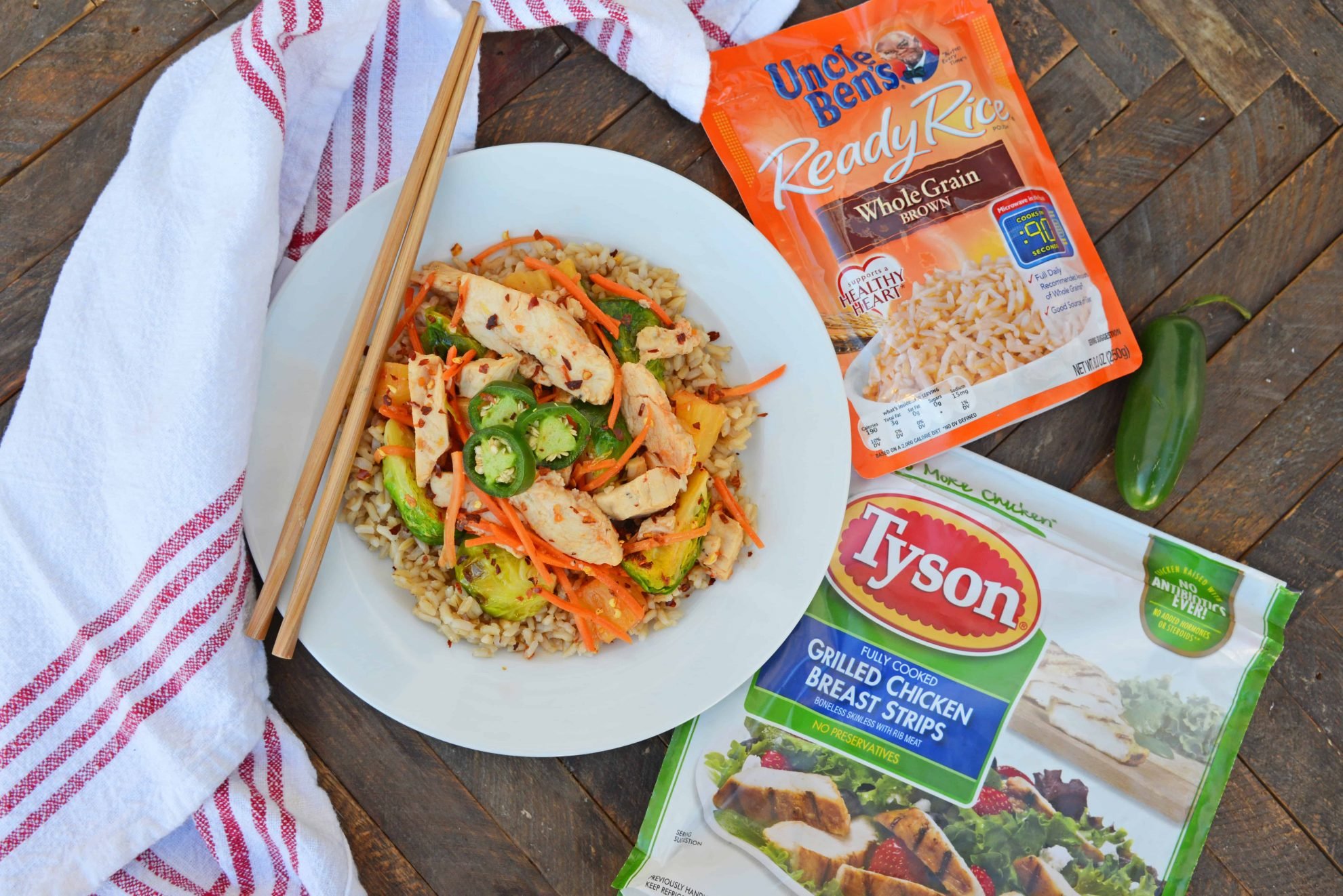 Quick Szechuan Chicken and Rice is an easy dinner recipe featuring chicken strips, brussels sprouts, carrots and pineapple over brown rice. All ready in 15 minutes! #quickchickendinners #szechuanchicken www.savoryexperiments.com 