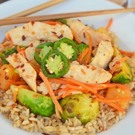 Quick Szechuan Chicken and Rice is an easy dinner recipe featuring chicken strips, brussels sprouts, carrots and pineapple over brown rice. All ready in 15 minutes! #quickchickendinners #szechuanchicken www.savoryexperiments.com