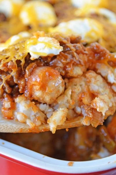 Sloppy Joe Tater Tot Casserole combines layers of crispy tater tots with homemade sloppy Joe mix, cream cheese and cheddar for the ultimate quick meal or party food! #tatertotcasserole #sloppyjoes www.savoryexperiments.com